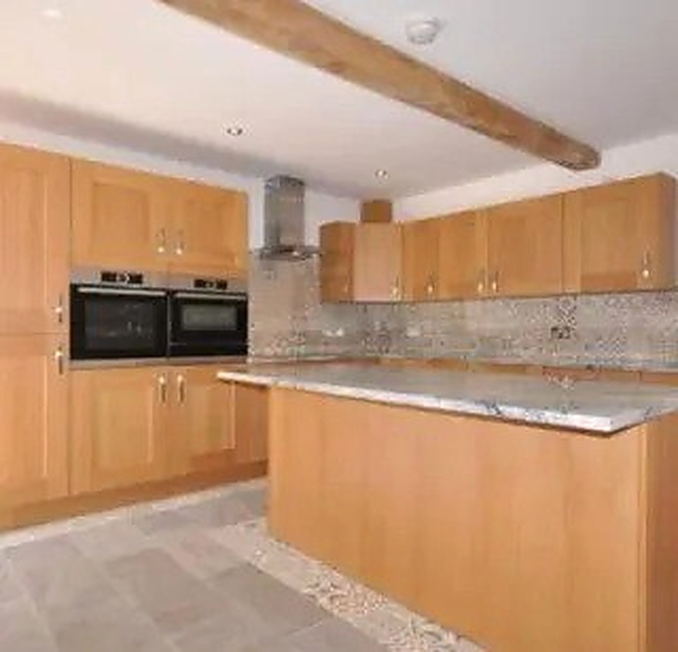 Timber kitchen with central island and exposed ceiling beam in a Derbyshire home
