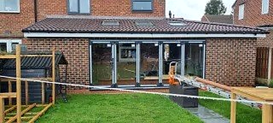 Completed brick house extension in Chesterfield with bi-fold doors and roof lanterns