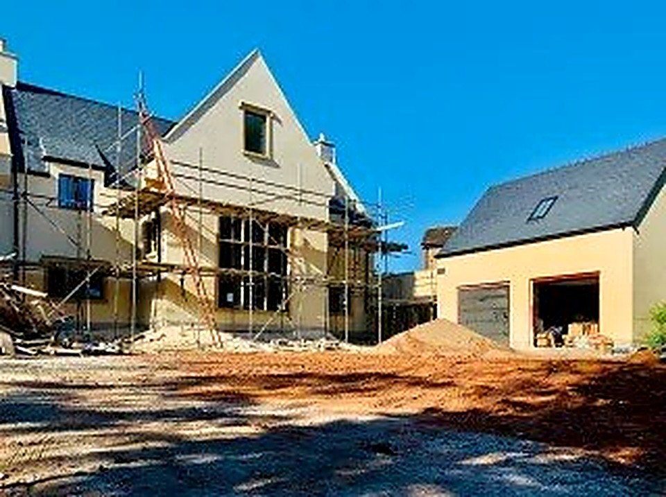 Rendered luxury new build home with detached garage under a clear blue sky, Chesterfield