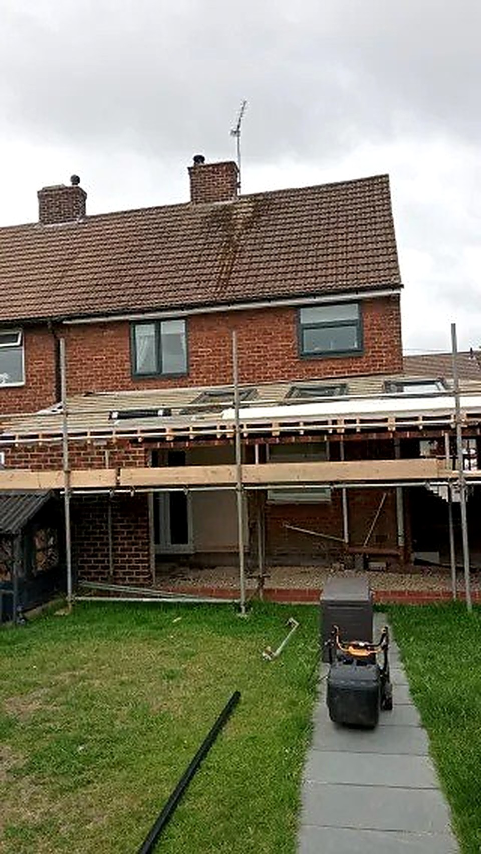 Scaffolding in place during the roof stage of a brick house extension, Derbyshire
