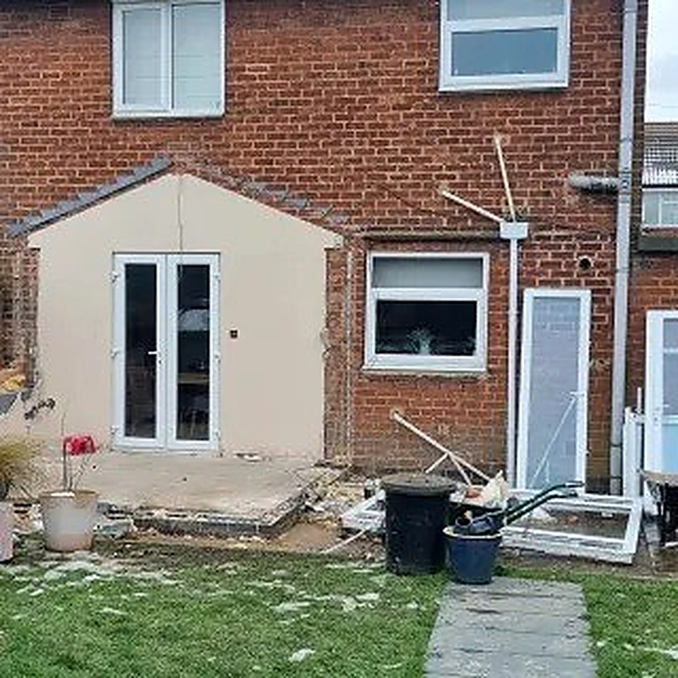 Single-storey brick extension mid-construction with white French doors, Derbyshire